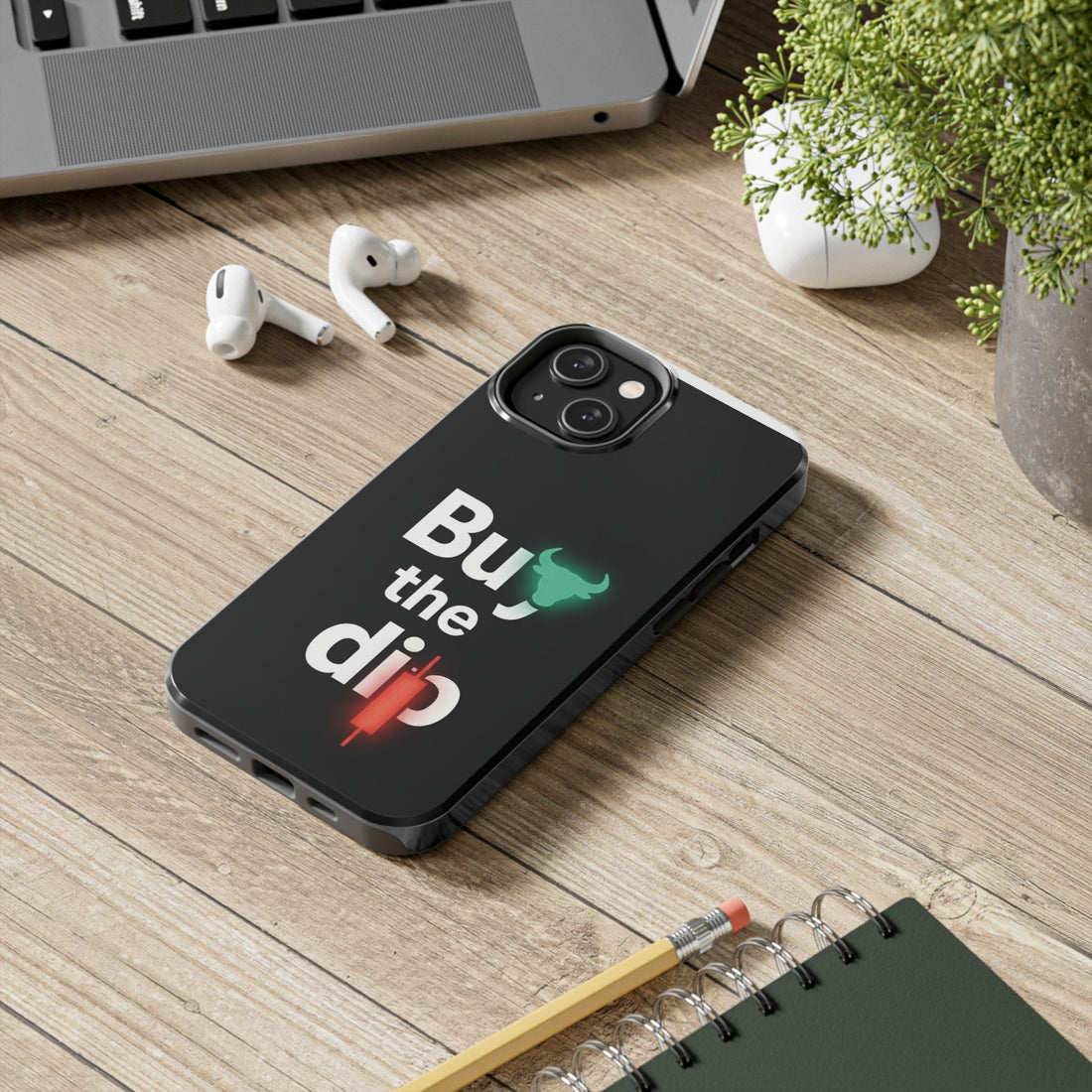 Buy the Dip tough phone case on a wooden desk beside a laptop, earbuds and a notebook