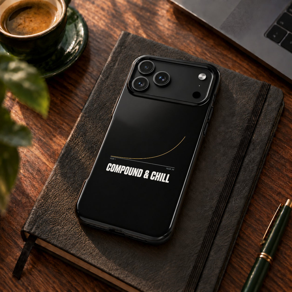 Compound and Chill phone case for iPhone 17 Pro Max, on a desk with coffee and a notebook